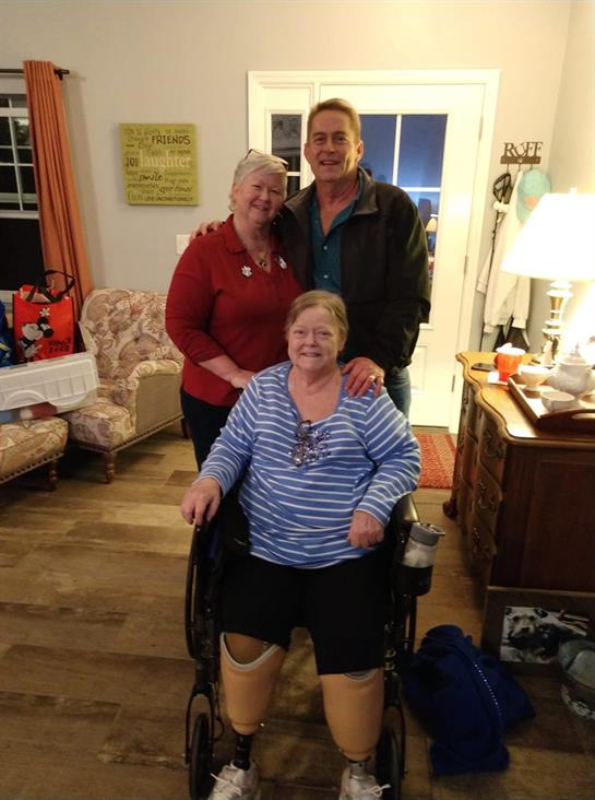 Three family members enjoy time together in a warm living room, filled with laughter and joy.