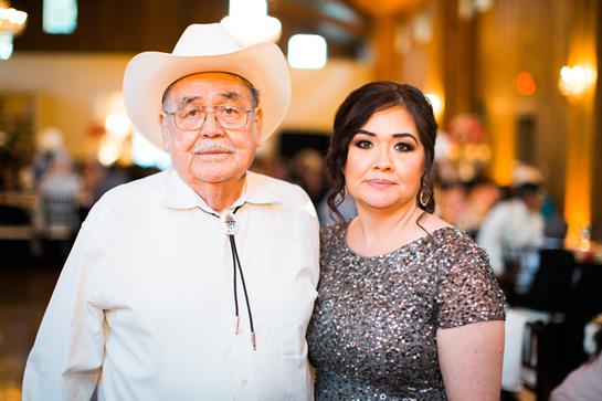 Two family members pose together, showcasing a blend of cultures in elegant attire.
