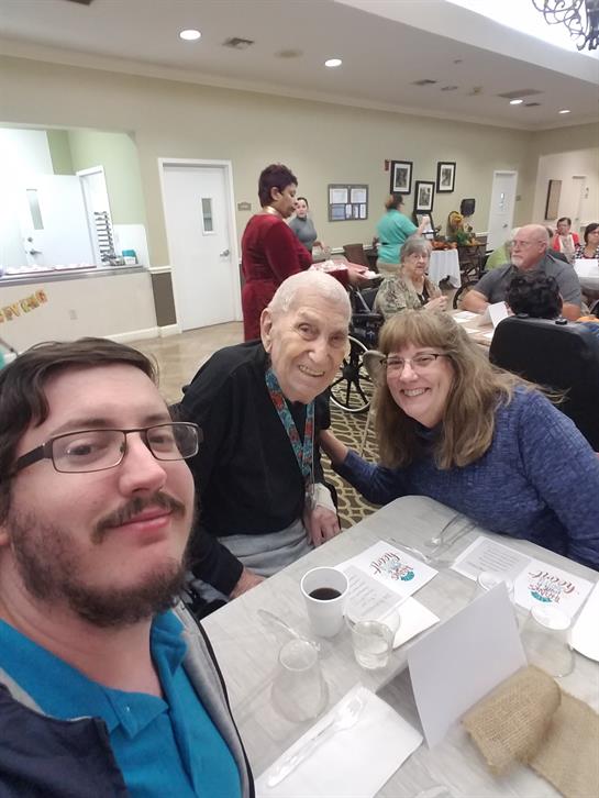 Adults share smiles and conversation during a lively gathering at a community center event.
