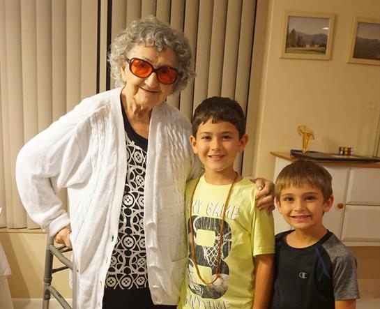 Two boys joyfully pose with their grandmother, highlighting their loving family bond.