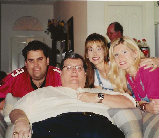 Friends gather in a cozy living room, smiling and posing together for a fun photo.