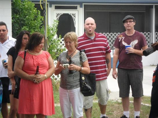 Friends gather in a backyard for a lively summer afternoon filled with conversation and drinks.