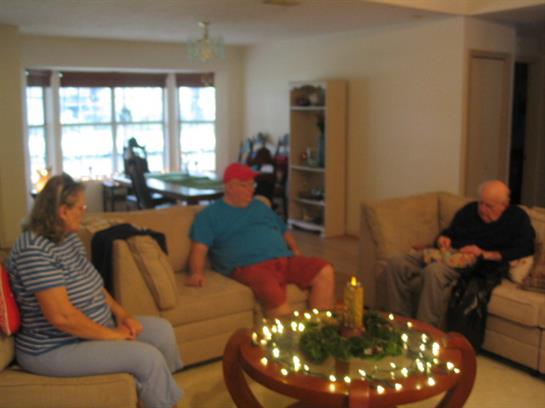 Three friends enjoy a quiet afternoon in a well-lit living room adorned with decorations.