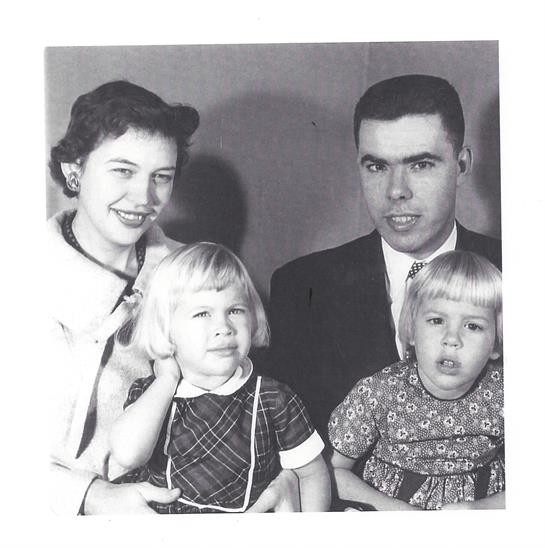 A family poses for a portrait, capturing two children with their loving parents.