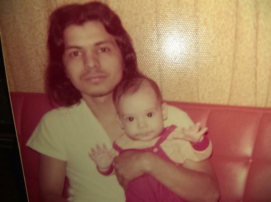 A man holds a baby in a warm atmosphere, showcasing a loving connection from the past.