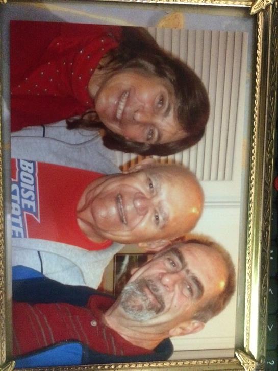 Three friends pose together, smiling warmly, capturing a memorable moment at home.