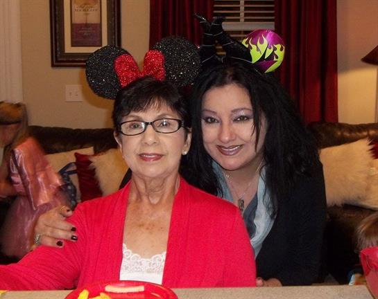 Two women wear festive headbands while celebrating together at home, enjoying a joyful moment.