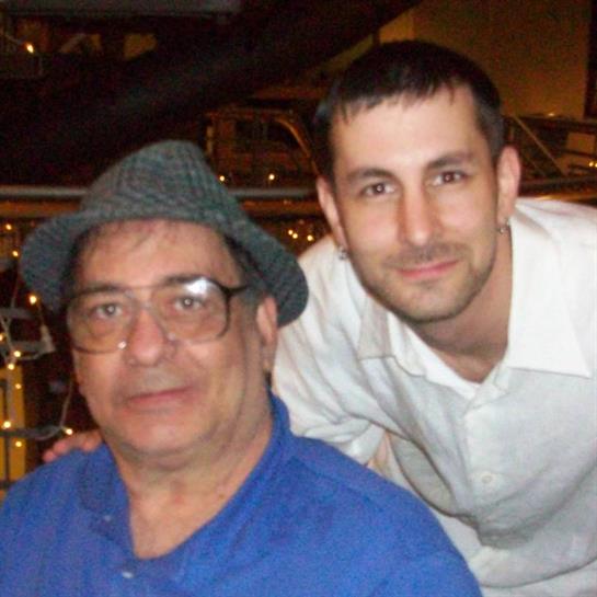 Two individuals pose for a photograph in a lively restaurant, enjoying their time together.