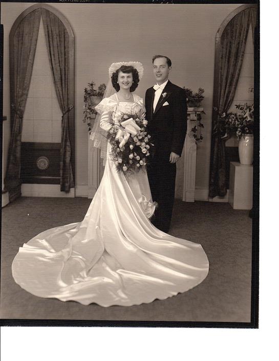 A bride in a beautiful gown and a groom in a tuxedo capture a moment of joy and love.