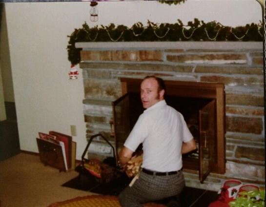 A man prepares the fireplace for a cozy get-together with family and friends.