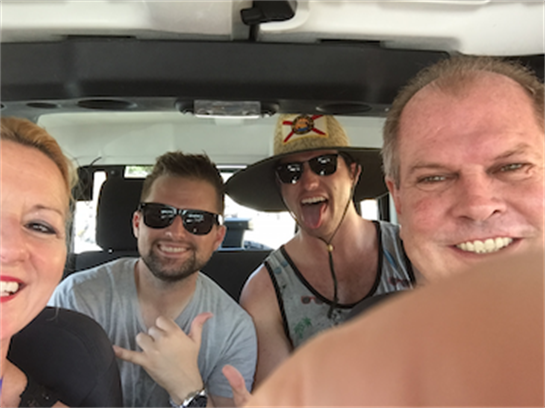 Group of friends enjoy a fun car ride, laughing and making memories in a coastal location.