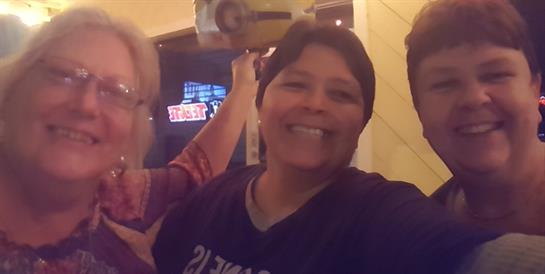 Two friends are smiling and posing for a fun photo while celebrating together at night.