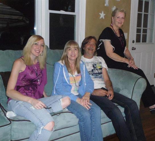 Four friends share laughter and stories while sitting together in a relaxed living room setting.