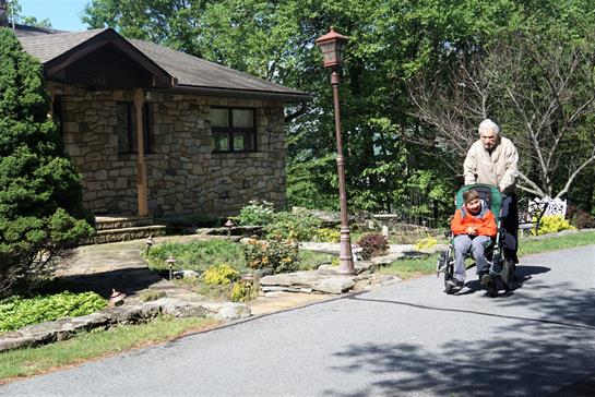 A family spends a warm, sunny day outdoors, relaxing near a lovely stone house.