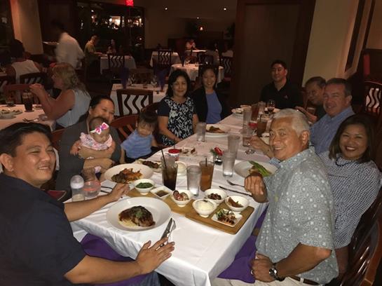 A group of people enjoys a festive meal together at a restaurant, sharing food and laughter.