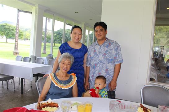 Four family members enjoy a meal together, capturing a moment of joy and connection.