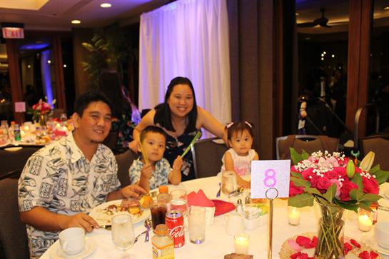 Family members enjoying dinner together, sharing laughter and food at a festive gathering.