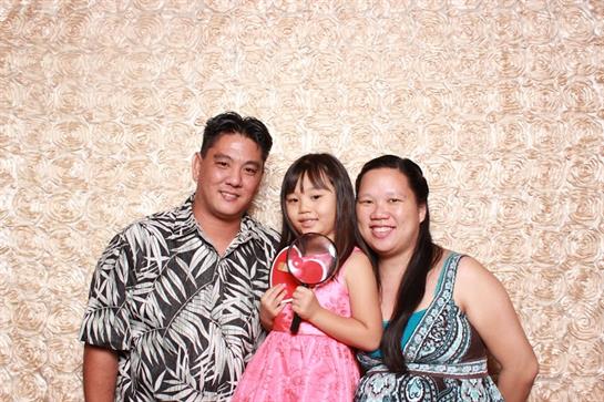A joyful family poses for a picture at a celebration, with smiles and playful expressions.