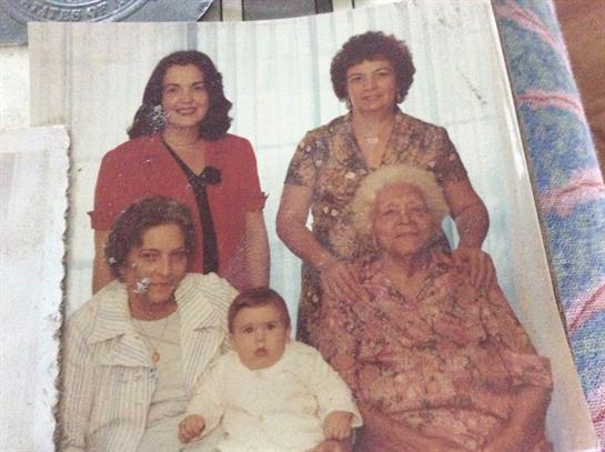 A close-knit family poses together in a warm living room, celebrating unity across generations.