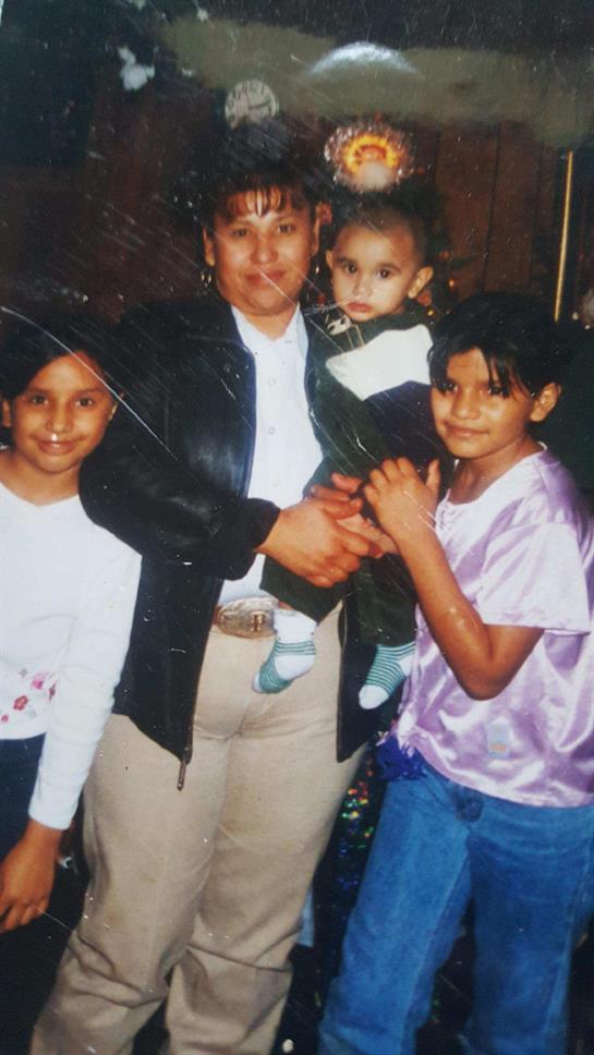 A mother poses with her three children, capturing a warm family moment in a welcoming space.