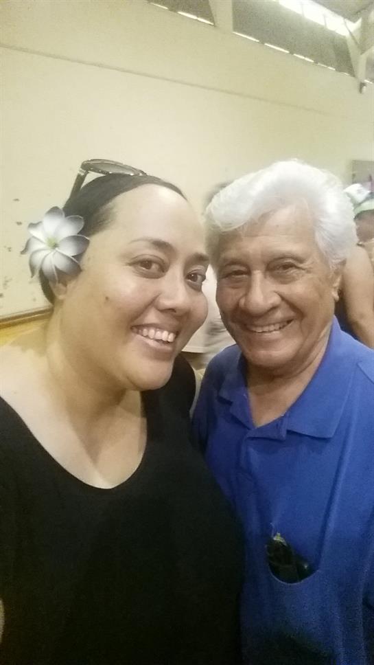 Two friends share laughter and a close moment at a lively social event surrounded by others.