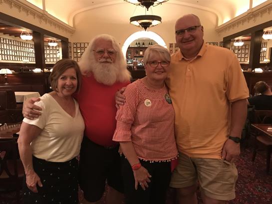 Friends pose for a cheerful photo in a cozy restaurant, enjoying their evening together.