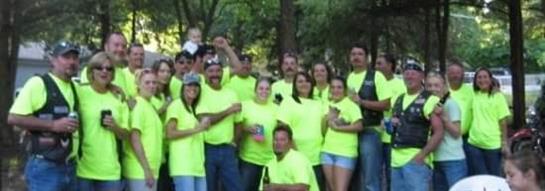 A joyful group in neon shirts enjoying a fun outdoor day with friends and family.