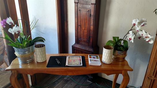 A wooden table displays decorative vases and books in a warm, inviting indoor space.