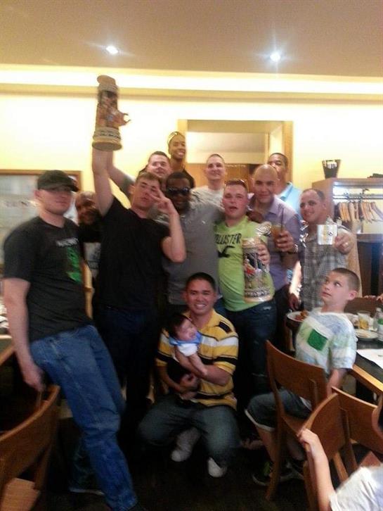 Friends gather in a restaurant, raising glasses and enjoying drinks while celebrating together.