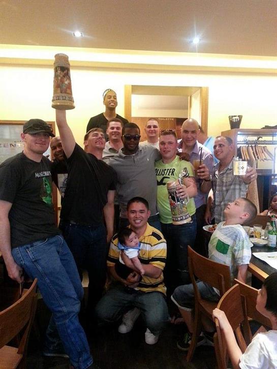 Friends gather in a lively restaurant, raising beer steins and enjoying each other's company.