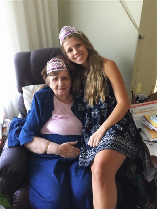 A joyful grandmother and granddaughter share a warm embrace while celebrating together at home.
