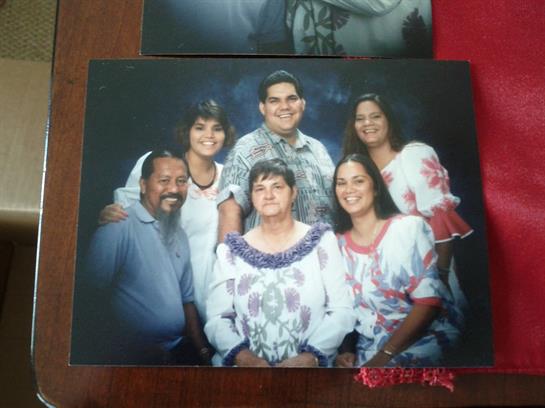 A joyful family poses together in casual clothing, showcasing warmth and connection.