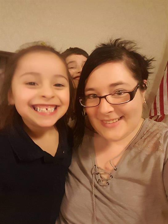 Mother and daughter share a joyful moment, smiling brightly in a warm home environment.