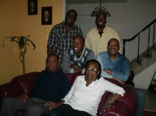 Family members pose happily together in a warm living room setting, surrounded by comfort.