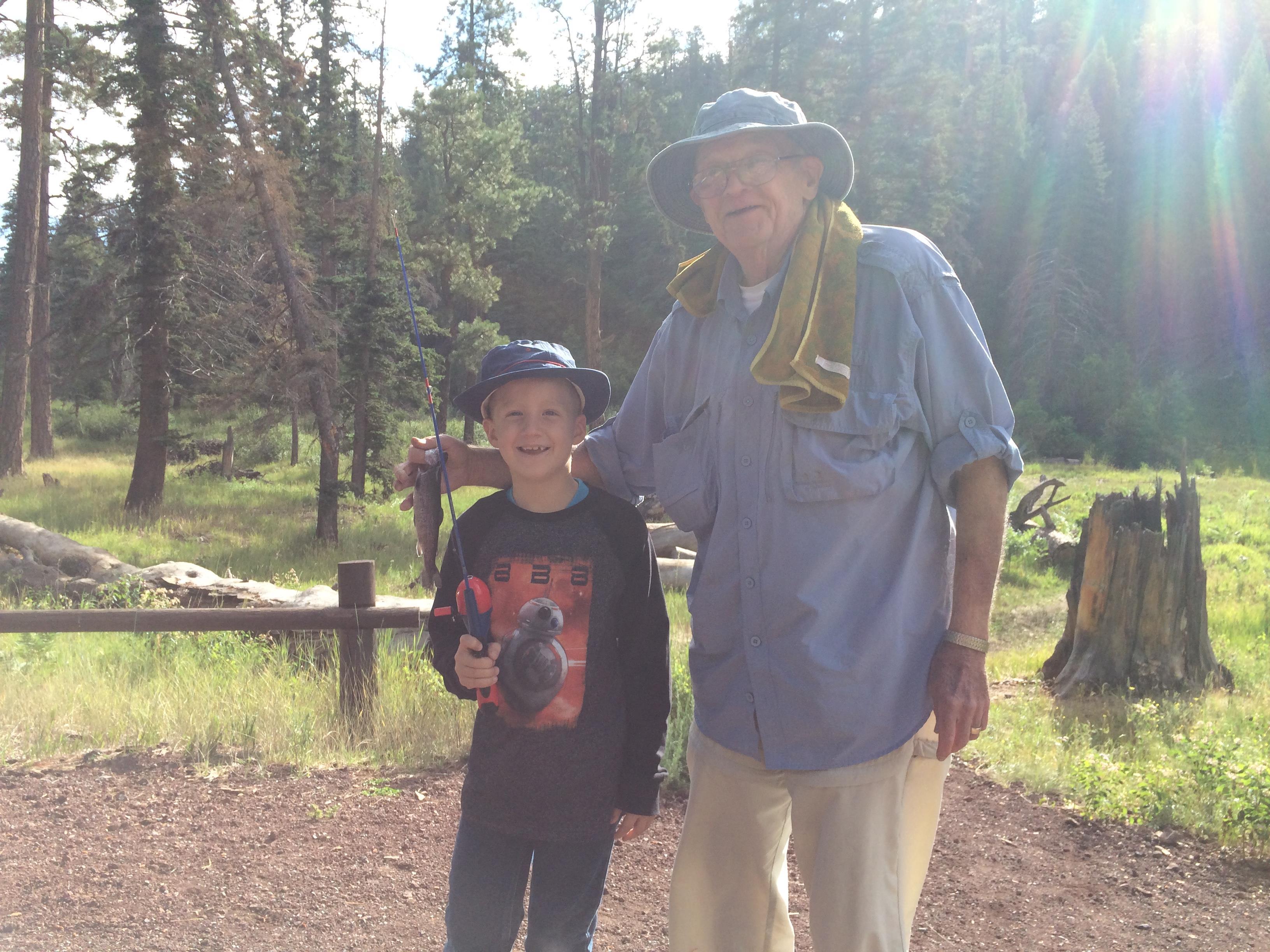 An old man and a boy standing in a forest