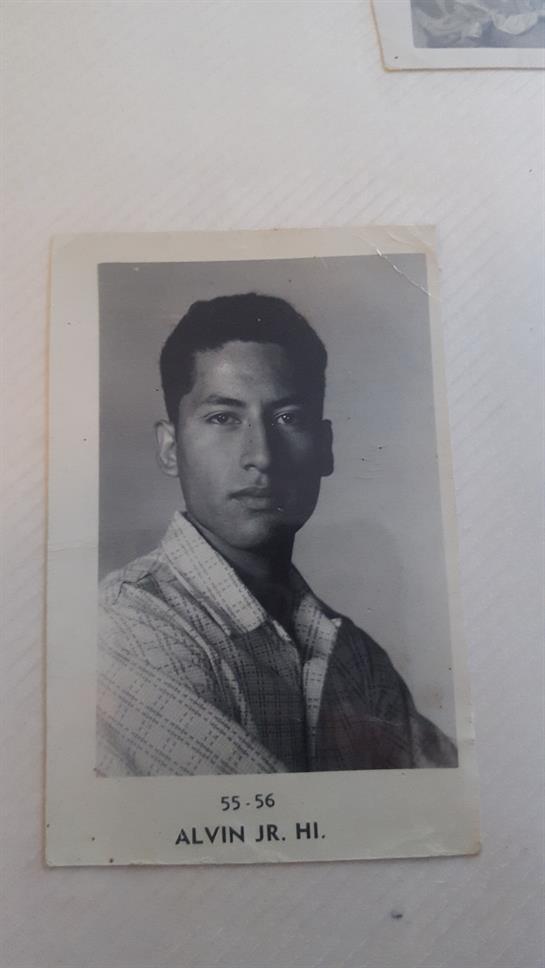 Young man poses confidently with arms crossed, displaying a thoughtful demeanor and serious look.