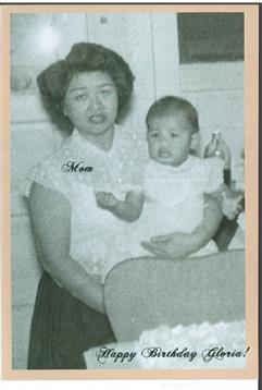 A mother tenderly holds her baby in a cozy kitchen, capturing a heartfelt family moment.
