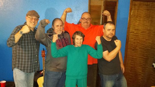 A group of five friends shows off their strength and camaraderie in a cozy room.