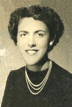 A young woman smiles confidently in a vintage portrait featuring elegant attire and pearls.