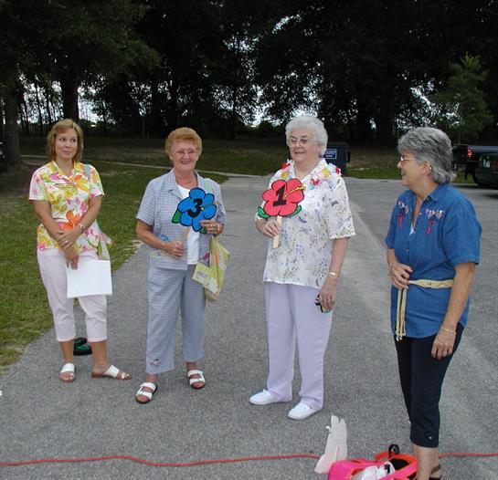 Seniors engage in a lively competition, holding numbers while enjoying a sunny day outdoors.