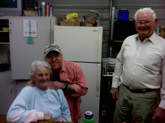 Three friends enjoy each other's company in a garage filled with laughter and warmth.