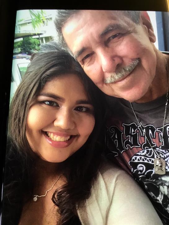 A man and a woman share smiles while posing for a photo outdoors, capturing a happy moment.