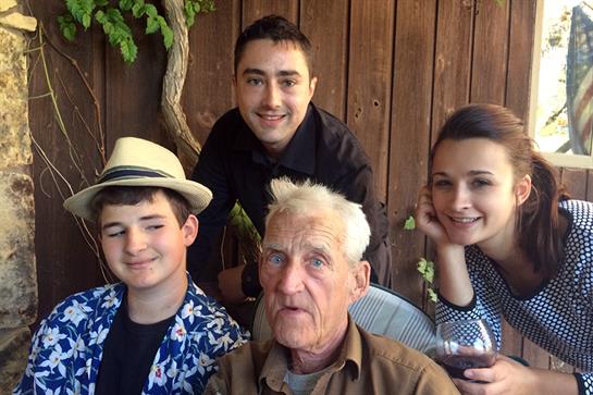 Four relatives pose together outdoors, displaying joy and affection in a cozy environment.