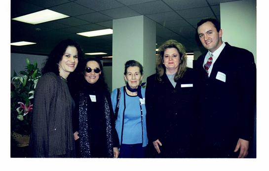 Five individuals gather for an engaging networking event in a contemporary office space.