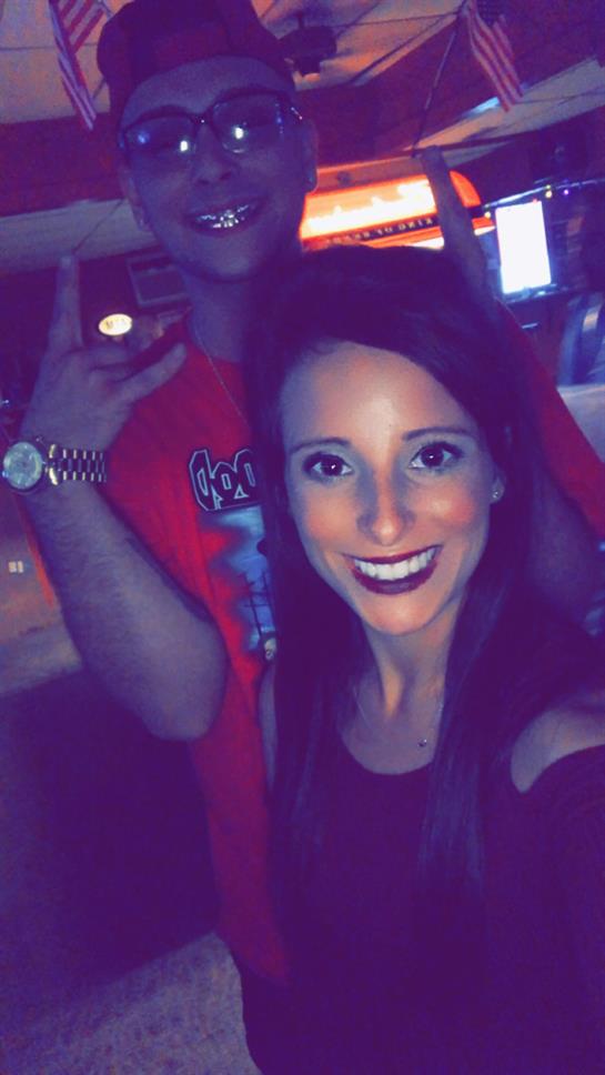 Friends are celebrating at a bar, smiling and posing for a fun group selfie during the night.