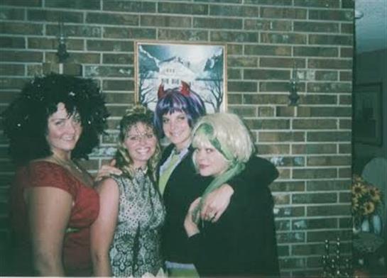 Friends gather at a themed party, showcasing colorful outfits and playful wigs in a cozy atmosphere.