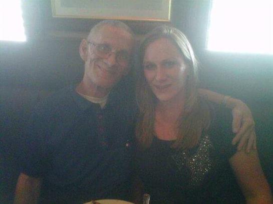 A cheerful man and woman share a lighthearted moment while seated at a dining table.