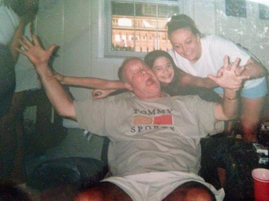 Two children playfully interact with an adult, showcasing joy and laughter in a cozy home setting.