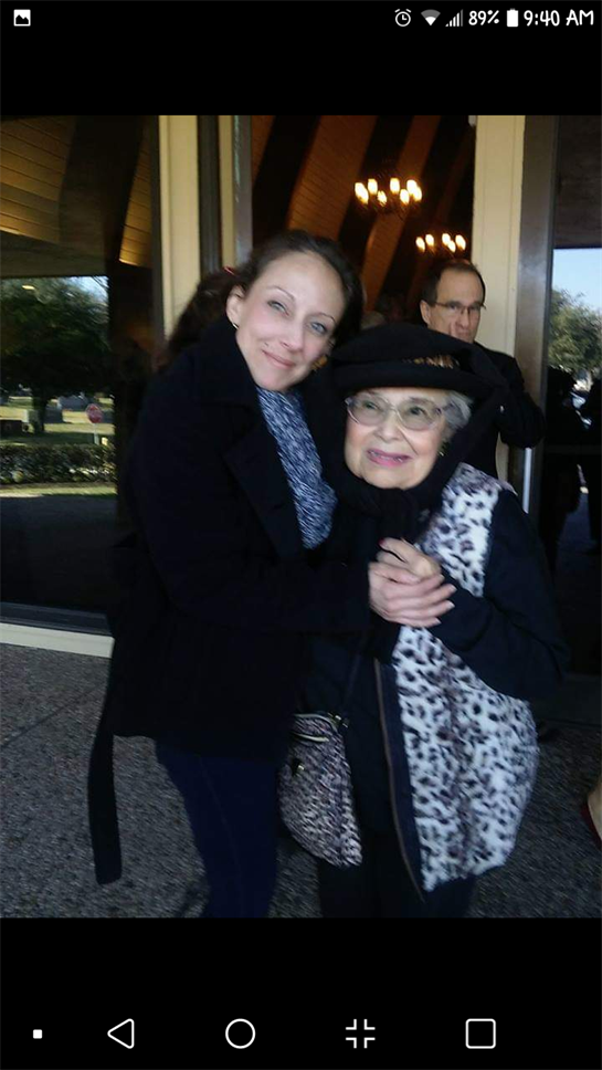 Two women enjoy a joyful moment together outside a venue, radiating warmth and affection.