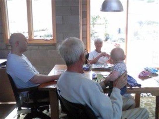 Seniors and a baby share joyful moments in a warm, inviting setting with natural light.